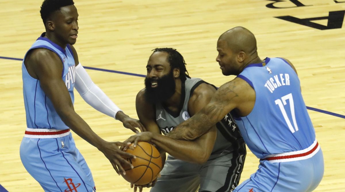 James Harden #13 of the Brooklyn Nets is pressured by P.J. Tucker #17 of the Houston Rockets and Victor Oladipo #7 at Toyota Center on March 03, 2021 in Houston, Texas.